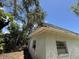 Angle view of home exterior showing peeling paint and overgrown trees at 902 Marshall St, Clearwater, FL 33755