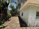Side view of home's exterior shows peeling paint and overgrown vegetation at 902 Marshall St, Clearwater, FL 33755