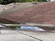 View of a flat roof surface, showing pooling water with shingles from a nearby sloped roof in the background at 902 Marshall St, Clearwater, FL 33755