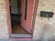 Entryway with a pink front door, brick facade, and a vintage mailbox displaying the home's exterior at 902 Marshall St, Clearwater, FL 33755