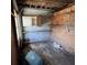 Garage with shelves, cabinet, cement block wall, and dirty floor. Needs cleaning and possibly repairs at 902 Marshall St, Clearwater, FL 33755