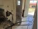 Damaged kitchen featuring tile flooring leading to the entrance and a bathroom with a tub at 902 Marshall St, Clearwater, FL 33755