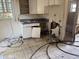 Damaged kitchen featuring tile flooring, a window, and older-style cabinetry with a broken door at 902 Marshall St, Clearwater, FL 33755
