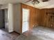 Living room featuring paneled walls, a ceiling fan and an exterior door with access to the outside at 902 Marshall St, Clearwater, FL 33755