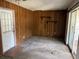 Living room featuring paneled walls and a sliding glass door with access to an enclosed outdoor space at 902 Marshall St, Clearwater, FL 33755