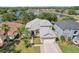 Aerial shot showcasing a home with a lake view, mature trees and a two-car garage at 10435 Deerberry Dr, Land O Lakes, FL 34638