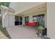 Covered back porch with red cushioned swing and sliding glass doors to the interior at 10435 Deerberry Dr, Land O Lakes, FL 34638