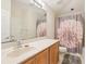 Bathroom featuring wood cabinets, bathtub with shower, and decorative flower curtain at 10435 Deerberry Dr, Land O Lakes, FL 34638