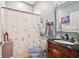 Hall bathroom with vanity, toilet and shower with flower-patterned curtain at 10435 Deerberry Dr, Land O Lakes, FL 34638