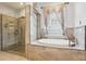 Bright bathroom featuring a glass shower, soaking tub, and elegant marble countertops at 10435 Deerberry Dr, Land O Lakes, FL 34638