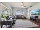Spacious living room featuring a comfortable sectional sofa, large windows, and stylish rug flooring at 10435 Deerberry Dr, Land O Lakes, FL 34638