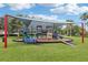 Community playground featuring slides, ramps, and other playground equipment on a well-maintained lawn at 10435 Deerberry Dr, Land O Lakes, FL 34638