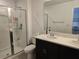 A modern bathroom with a glass-enclosed shower and double vanity with a neutral color scheme at 10573 Oakside Dr, Palmetto, FL 34221