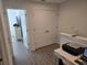 Hallway featuring luxury vinyl plank flooring with a view to a bedroom with a dresser and television at 10573 Oakside Dr, Palmetto, FL 34221