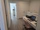 Hallway featuring luxury vinyl plank flooring with a view to a bedroom with a dresser and television at 10573 Oakside Dr, Palmetto, FL 34221