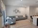 Living area with a large gray sectional sofa and view to the kitchen island and bar seating at 10573 Oakside Dr, Palmetto, FL 34221