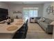 Open-concept living room features a large sectional sofa, a spacious island with bar seating, and ample natural light at 10573 Oakside Dr, Palmetto, FL 34221