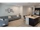 Open-concept living area with a comfortable gray sectional sofa, adjacent to a kitchen island with bar stools at 10573 Oakside Dr, Palmetto, FL 34221