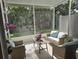 Relaxing screened in porch with wicker furniture, views of lush greenery, and natural light at 10573 Oakside Dr, Palmetto, FL 34221