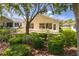 A verdant backyard features manicured shrubbery, mature trees, and a patio area with green chairs at 11078 Heathrow Ave, Spring Hill, FL 34609