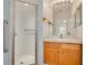 Modern bathroom with a glass shower door, wooden vanity, and a large mirror, designed for functionality and style at 11078 Heathrow Ave, Spring Hill, FL 34609