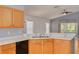 Bright kitchen with wooden cabinets, stainless steel sink, and a view into the dining and living areas at 11078 Heathrow Ave, Spring Hill, FL 34609