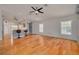Open living area with hardwood floors, a ceiling fan, bright windows, and a kitchen bar with seating at 11078 Heathrow Ave, Spring Hill, FL 34609