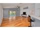 Spacious living room with hardwood floors, a sliding door to the lanai, and an open layout connecting to the kitchen at 11078 Heathrow Ave, Spring Hill, FL 34609