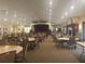 Large meeting room with a stage, tables, and chairs and fireplace for community events at 11078 Heathrow Ave, Spring Hill, FL 34609