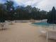 The community pool features a hot tub and several tables and chairs with umbrellas around it at 11078 Heathrow Ave, Spring Hill, FL 34609