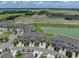 An aerial view of townhomes next to a large field, pond and view of the neighborhood at 11287 Cay Spruce Way, San Antonio, FL 33576