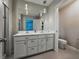 Bright bathroom with double vanity, neutral walls, and modern pendant lighting at 11287 Cay Spruce Way, San Antonio, FL 33576