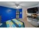room with shelving, blue accent wall, ceiling fan, and wall-mounted TV at 11287 Cay Spruce Way, San Antonio, FL 33576