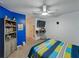 room with a blue accent wall, ceiling fan, wall-mounted TV, and shelving at 11287 Cay Spruce Way, San Antonio, FL 33576