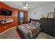 Cozy bedroom with an orange accent wall, grey furnishings, and modern decor at 11287 Cay Spruce Way, San Antonio, FL 33576