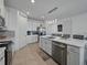 Open kitchen boasts an island with pendant lighting, stainless steel appliances, and white cabinetry at 11287 Cay Spruce Way, San Antonio, FL 33576