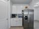 Bright kitchenette features stainless steel refrigerator, white cabinets and countertops at 11287 Cay Spruce Way, San Antonio, FL 33576