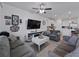 Open concept living room with tile flooring, ceiling fan, and white walls flowing to the kitchen at 11287 Cay Spruce Way, San Antonio, FL 33576