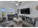 Comfortable living room features a ceiling fan, large TV, and a view of the backyard at 11287 Cay Spruce Way, San Antonio, FL 33576