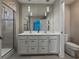 Contemporary main bathroom with a double vanity, modern lighting, and glass enclosed shower at 11287 Cay Spruce Way, San Antonio, FL 33576