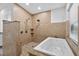 Bathroom featuring a tiled shower, a luxurious soaking tub, and elegant fixtures at 11320 Partridge Dr, Tampa, FL 33625