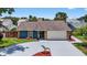 A beautiful front exterior showing a home with a paved driveway, an attached garage, and well-kept landscaping at 11320 Partridge Dr, Tampa, FL 33625