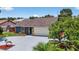 A well-manicured lawn and mature trees accent this home with blue siding and a two-car garage at 11320 Partridge Dr, Tampa, FL 33625