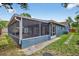 Back of house featuring a screened-in porch, providing an ideal spot for outdoor enjoyment and entertaining at 11320 Partridge Dr, Tampa, FL 33625