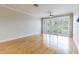 Bright bedroom with hardwood floors, ceiling fan, and large windows for natural light at 115 Brent Cir, Oldsmar, FL 34677