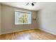 Bedroom features hardwood floors, neutral walls, and a window with plantation shutters at 115 Brent Cir, Oldsmar, FL 34677