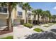 Townhome exterior showing attached garage, neutral color scheme, and a palm-tree-lined street at 115 Brent Cir, Oldsmar, FL 34677