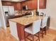 Kitchen with stainless steel appliances, light granite counters, dark cabinets, and seating at 115 Brent Cir, Oldsmar, FL 34677