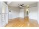 Bright living room with light hardwood floors, shutters, and modern ceiling fan at 115 Brent Cir, Oldsmar, FL 34677