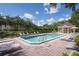 Community pool surrounded by lounge chairs, mature landscaping, and a gazebo at 115 Brent Cir, Oldsmar, FL 34677